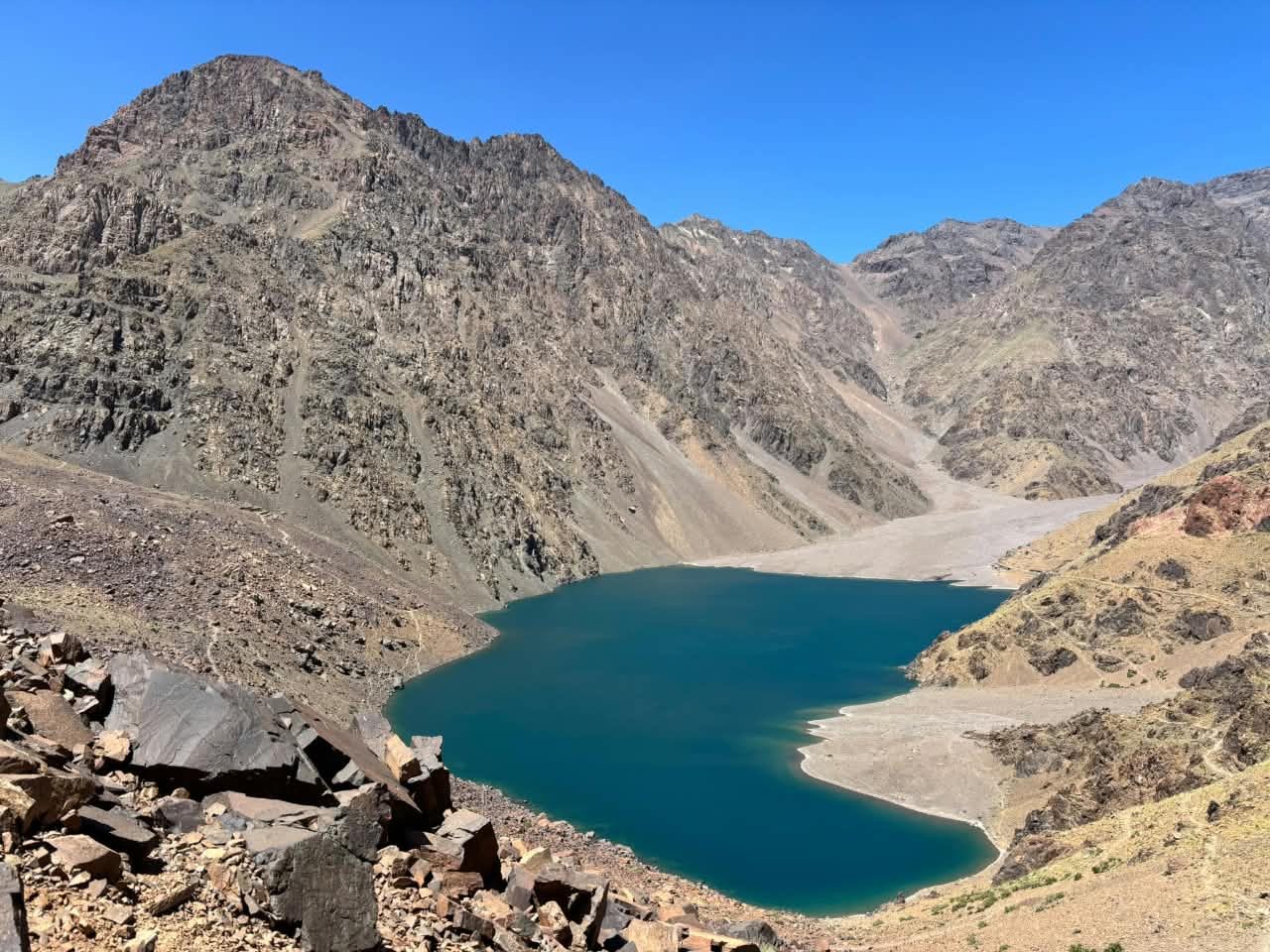 Turquoise alpine lake ringed by rocky High Atlas peaks